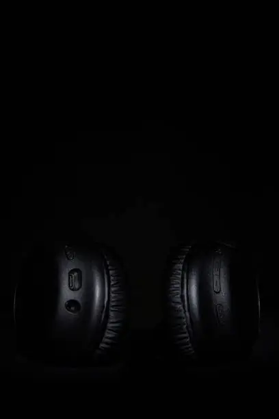 Detail of headphones on a black background.