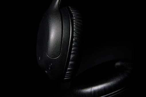 Detail of headphones on a black background.