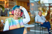 Smiling young woman with colorful hair.