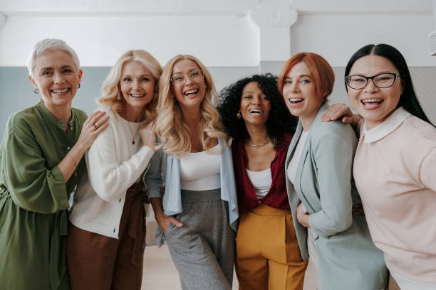istock Multi-ethnic group of confident mature women embracing and smiling at camera 1490126111
