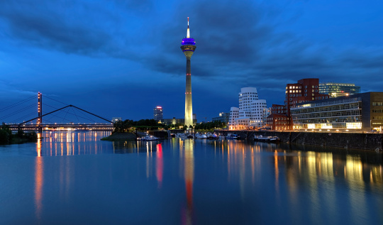 Evening view of the Media Harbor in Dusseldorf with Rheinturm TV tower and Buildings of Neuer Zollhof, Germany