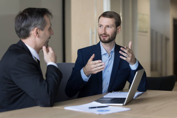 istock Ambitious business man talking to boss, elder colleague at workplace 1490130124