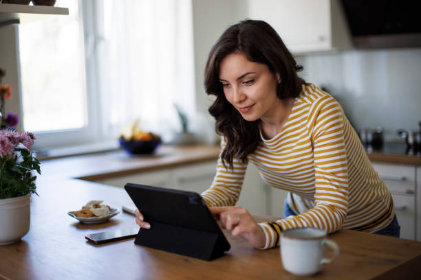 Young woman using digital tablet at home stock photo