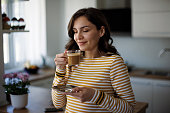 Young smiling woman enjoying coffee at home