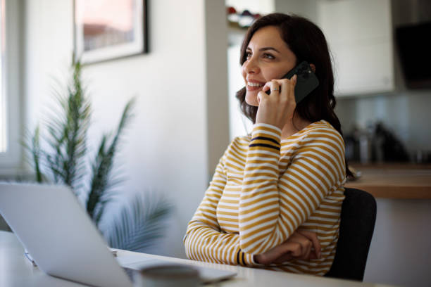 istock Young woman talking on smart phone at home office 1490133838