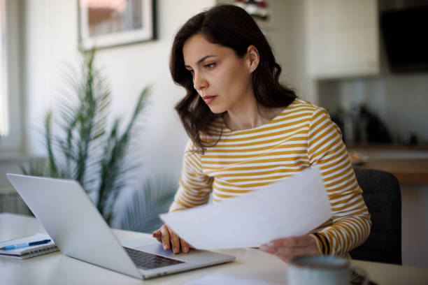 Serious young woman working at home stock photo
