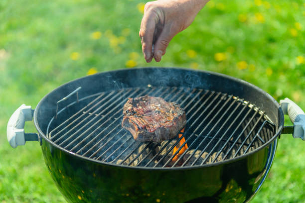 istock Person adding coarse salt to sirloin on BBQ 1490135923