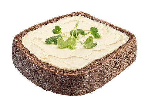 Slice of rustic rye bread with smeared butter isolated on white background with clipping path