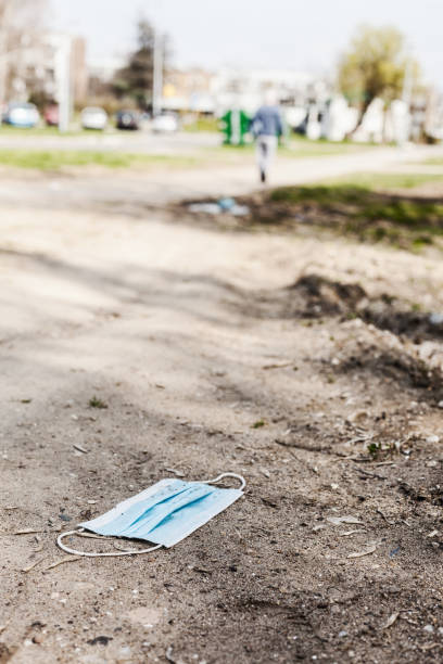 istock Environment damage, surgical mask discarded at city street 1490141319