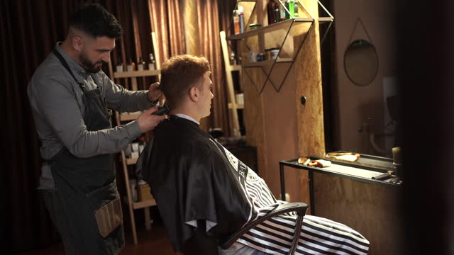 Redhead man getting his haircut at the barbershop