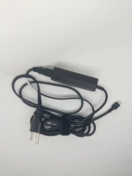 The power charging cable for the Chromebook battery was captured in a mini studio using a mobile phone camera