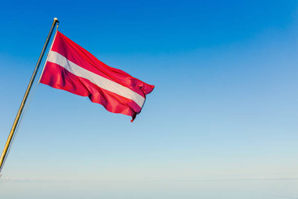 istock Flag of Latvia against blue sky. 1490143929