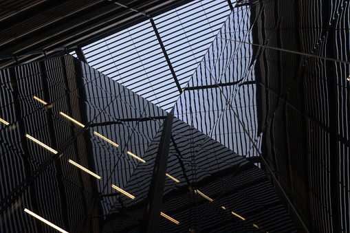 Interior of a structure surrounded by mirrored surfaces with a sky light at the top, London, England.