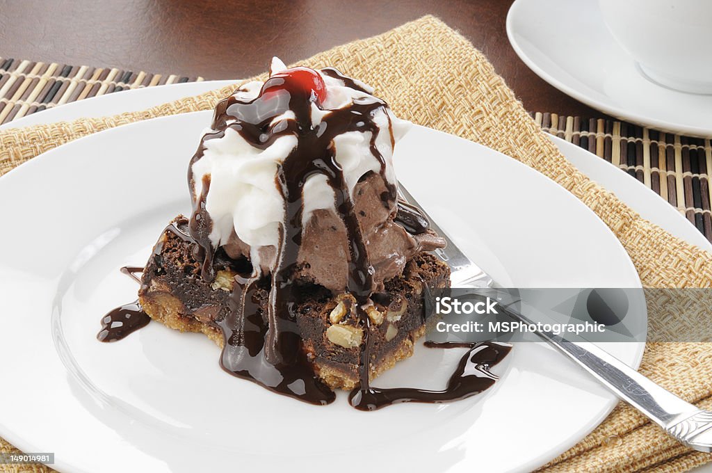 Fudge brownie with ice cream A chocolate fudge brownie with ice cream, whipped cream and a cherry Bowl Stock Photo