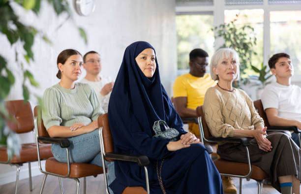 istock Young asian girl sitting in lecture hall with group 1490150445