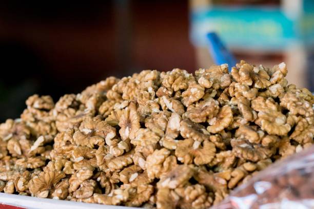 A pile of walnuts in a large container, for sale at a stall in a green market in Tetovo, Macedonia. A pile of walnuts in a large container, for sale at a stall in a green market in Tetovo, North Macedonia, former Yugoslavia. Fresh produce. tetovo stock pictures, royalty-free photos & images