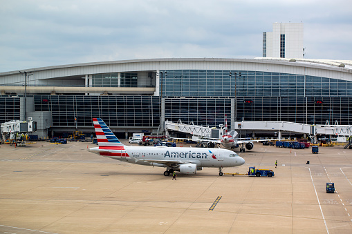 American Airlines Airbus A319-112 aircraft with registration N177XF towed by tug truck from gate at Dallas/Fort Worth International Airport in June 2022.