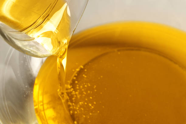 istock Pouring cooking oil from jug into bowl, closeup 1490188444
