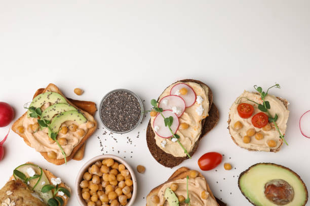 istock Delicious sandwiches with hummus and different ingredients on white background, flat lay. Space for text 1490188533