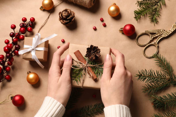 istock Woman decorating gift box on wrapping paper, top view. Christmas present 1490197264