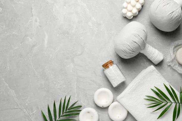 istock Flat lay composition with herbal massage bags and other spa products on grey marble table, space for text 1490200597
