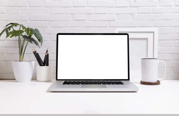istock Front view of laptop computer, coffee cup and potted plant on white table. Empty screen for your advertise design. 1490206002