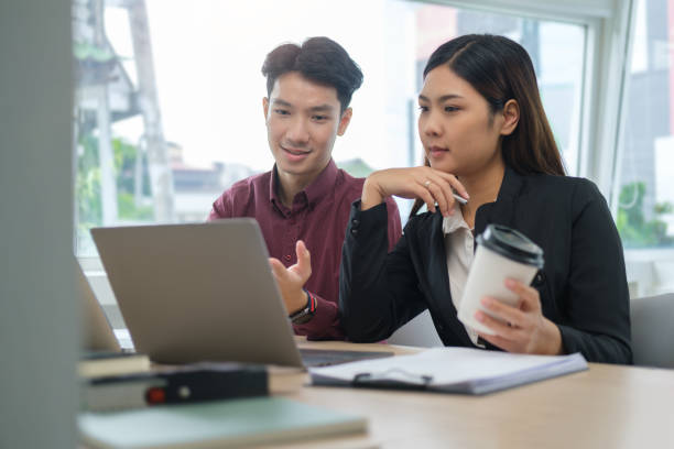 istock Young business colleagues looking at laptop screen and discussing financial data at office. 1490206036