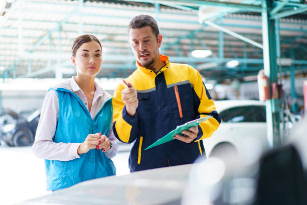 istock Woman and technician talking together in garage. 1490207786