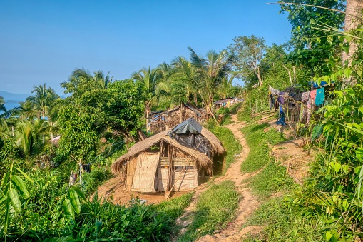 A small village of thatched huts in an indigenous Mangyan tribal community on a hillside on Mindoro Island. The small homes have no electricity or running water.
