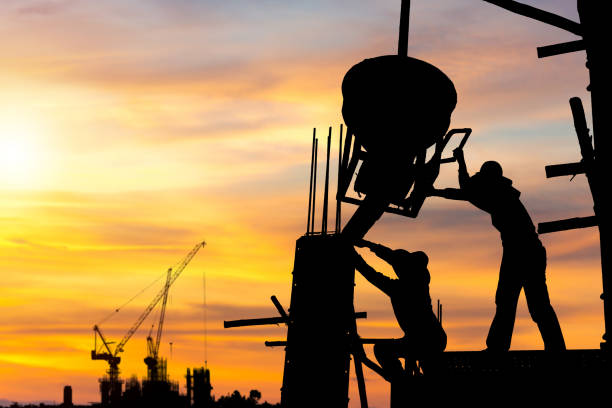 istock Silhouette of Engineer and worker team checking project at building site background, construction site with sunset in evening time background 1490218347