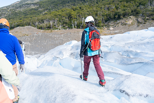 El Calafate Santa Cruz Argentina - January 13, 2023: The group guide is taking care of and explaining the wonders of the Perito Moreno Glacier.