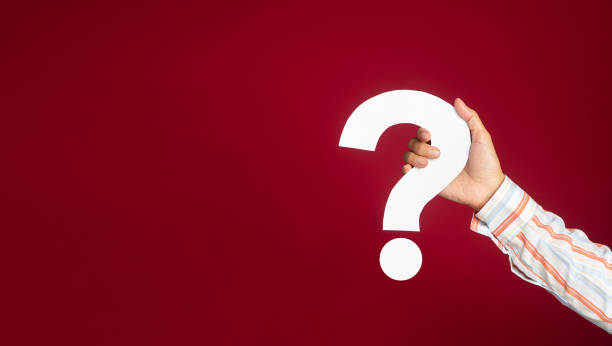 istock Hand holding a white question mark against a red background 1490232427