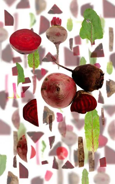 Abstract background made of Red Beet vegetable pieces, slices and leaves isolated on white.