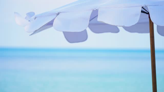 close up shot white umbrella on empty beach