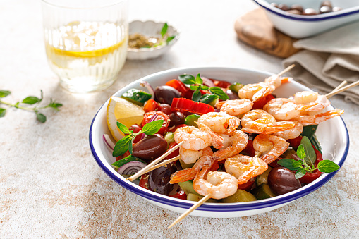 Shrimp kebab roasted on skewers and fresh vegetable salad