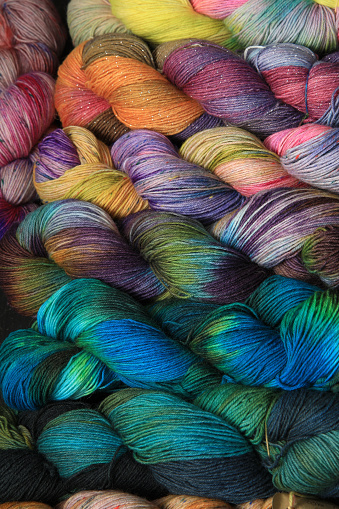 Multiple skeins of colourful handdied sock yarn, sock wool, with extreme vibrant colours for knitting socks and other craft projects as a hobby.