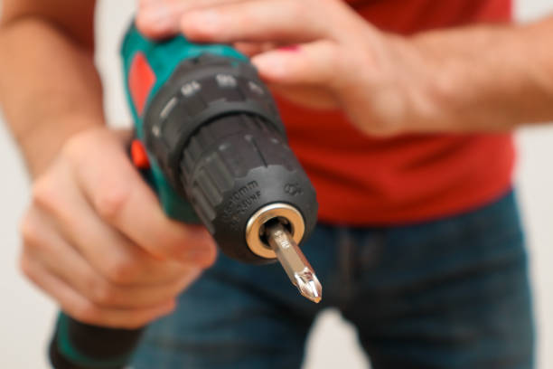 istock Hand holding cordless drill. Handyman with a tool screwdriwer drill. 1490247062