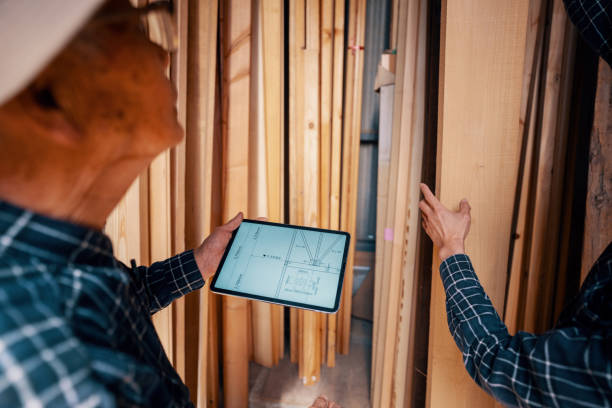 istock Two carpenters looking at blueprints on a digital tablet 1490247514