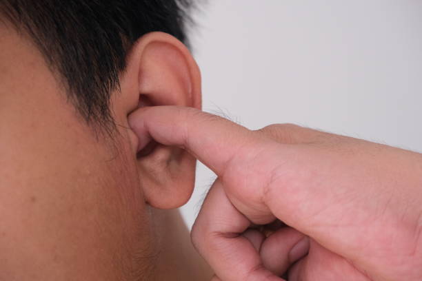 istock Close up of man picking his finger into his ear 1490248609