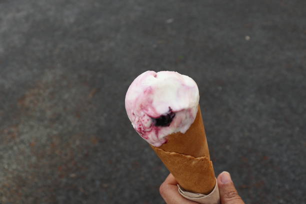 istock Someone holding Gelato blueberry ice cream cone 1490248764