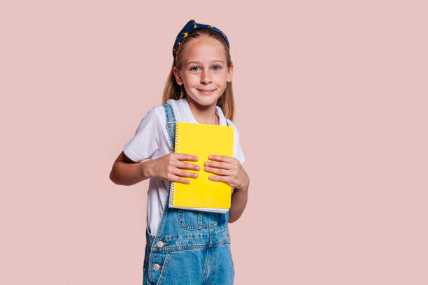 istock School girl holds a spiral notebook with two hands 1490249056