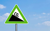 CO2 emission reduction sign green triangular shape against a clear blue sky