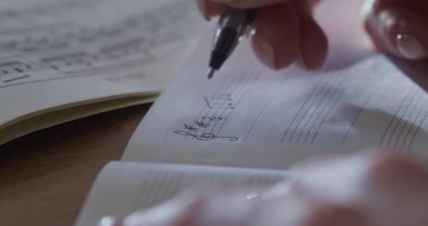 istock The hand writes on the notes on the stave. 1490252918