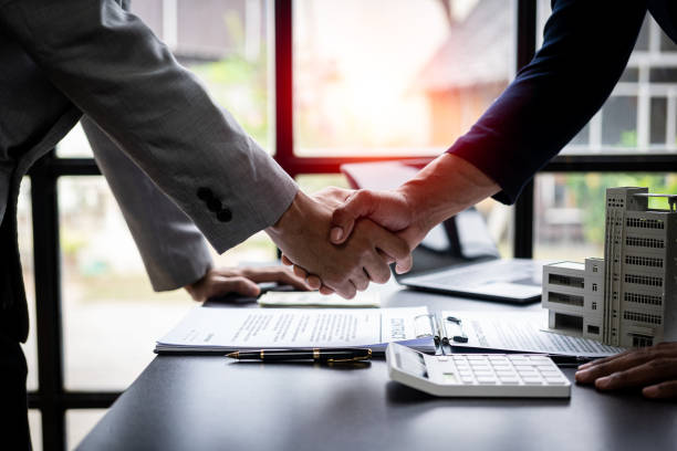 istock Successful handshake and agreement Real estate agent and client celebrating contracts completed after signing on home insurance and investment loans. house sale ideas 1490258109
