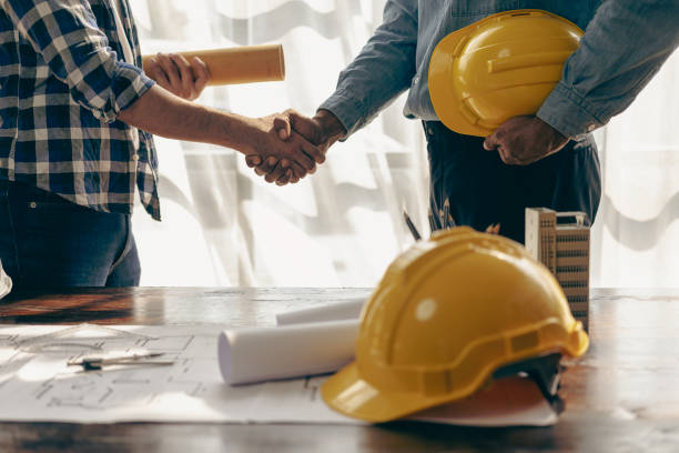 istock Construction workers holding helmets and vests are shaking hands. real estate concept Architect shaking hands with engineer or builder planning and successful meetings 1490258122