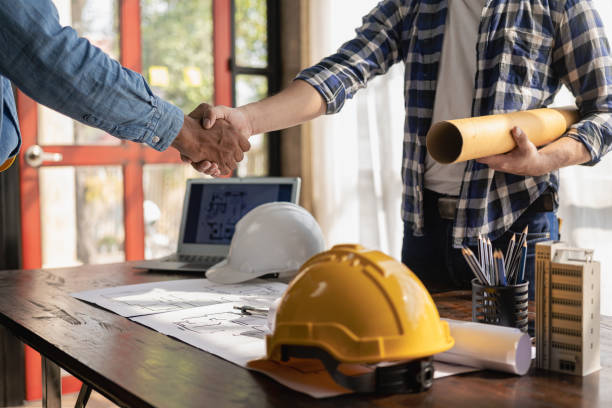 istock Construction workers holding helmets and vests are shaking hands. real estate concept Architect shaking hands with engineer or builder planning and successful meetings 1490258251