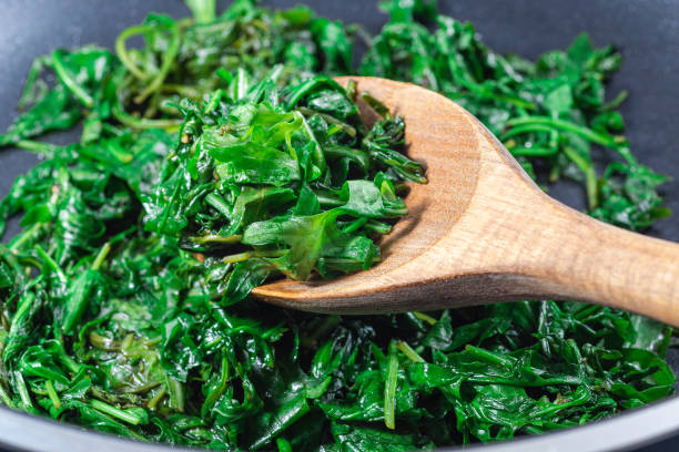 istock Wilted arugula or rocket salad, preparing a side dish to steak, in frying pan, horizontal 1490260302
