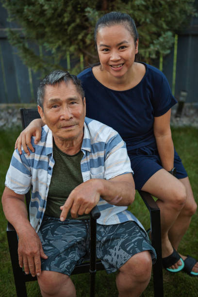 Bonding with grandfather Smiling cute 77 years old Vietnamese senior man with granddaughter in backyard vietnamese old man portrait stock pictures, royalty-free photos & images