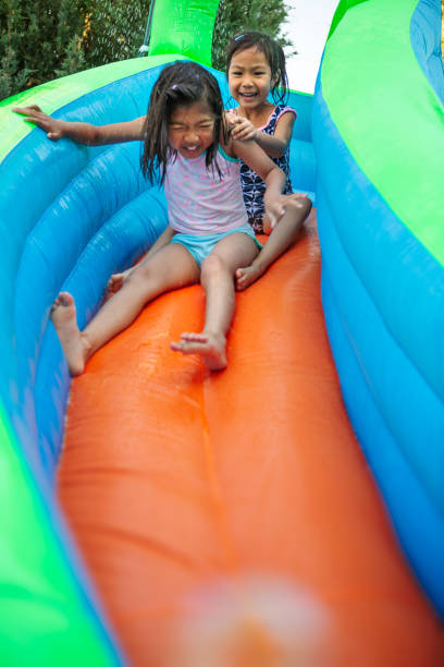 istock Sisters on inflatable water slide 1490265039