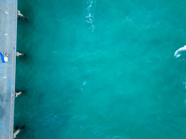 istock A blue sea water background with a white wave and pier 1490266841